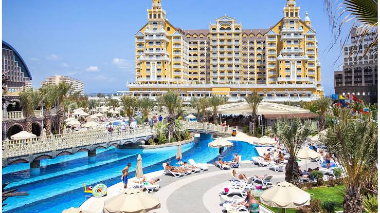 Hotel de Royal Holiday con alberca y personas nadando en un día soleado